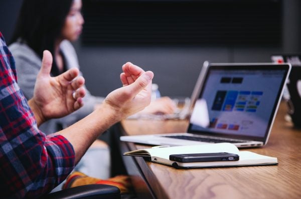 Someone gesturing with their hands at a conference table.